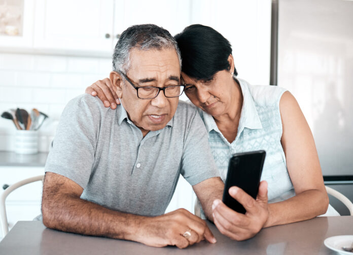 Shot of a senior couple looking unhappy while using a phone at home older couple on their phone
